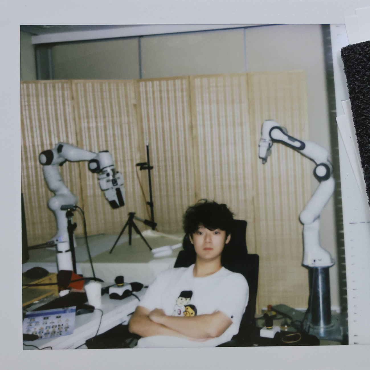 Qize Yu seated between two robot arms